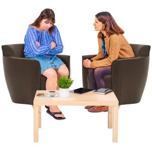 2 people talking together, one of them is looking down