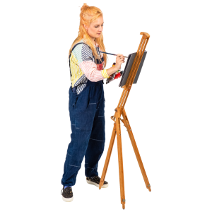 A young woman painting on a canvas set on a wooden easel.