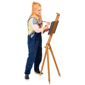 A young woman painting on a canvas set on a wooden easel.